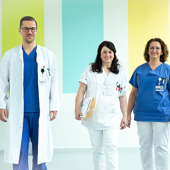 Drei Mitarbeitende auf einem Flur im Klinikum Drei Mitarbeitende auf einem Flur im Klinikum